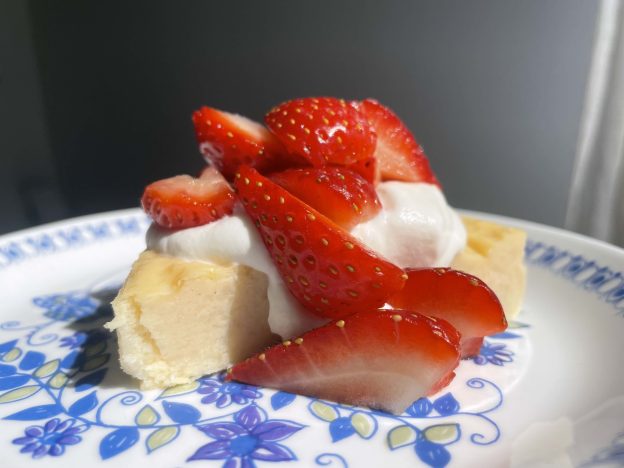 A slice of Swedish cheesecake topped with strawberries